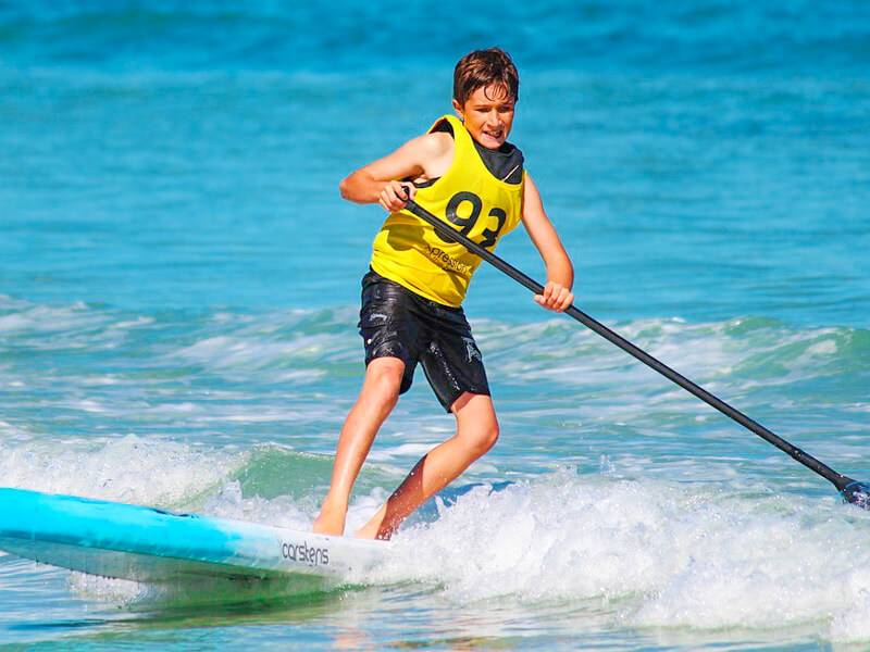 Junge steht auf Surfbrett